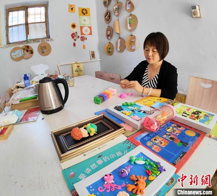 張美正在準(zhǔn)備給孩子們講故事用的道具?！∠臅枣?攝