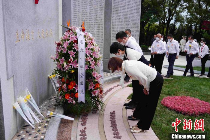 現(xiàn)場人員向人體器官捐獻者紀念碑獻花、鞠躬?！〈蘧办n 攝