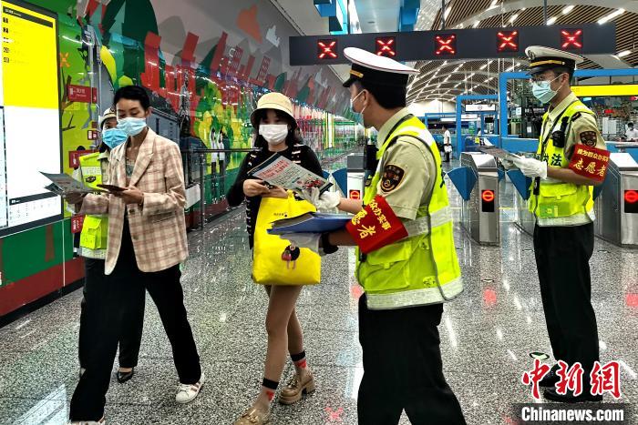 圖為交通執(zhí)法人員向出站旅客發(fā)放相關(guān)宣傳冊?！埿?攝
