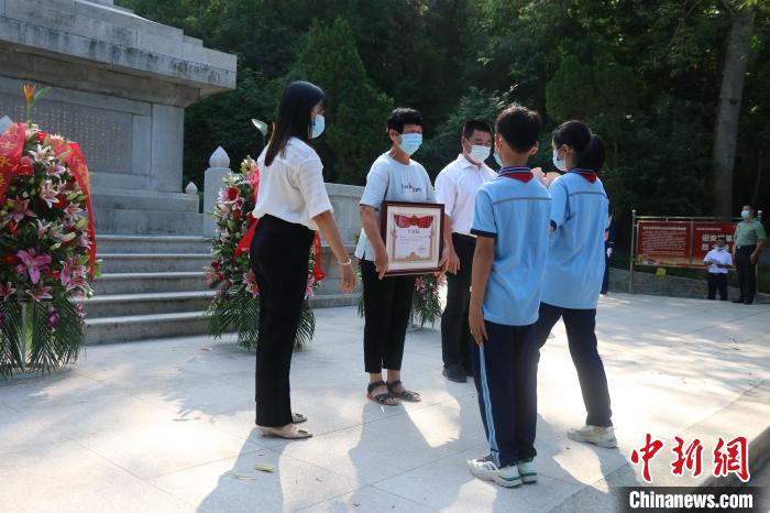 少先隊(duì)員向烈屬敬獻(xiàn)鮮花?！≌闹菔型艘圮娙耸聞?wù)局供圖