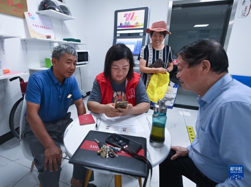 在浙江省杭州市臨安區(qū)玲瓏街道東山社區(qū)便民服務(wù)站，黨員志愿者幫助居民填寫(xiě)公租房申請(qǐng)資料（2022年8月17日攝）。新華社記者 徐昱 攝