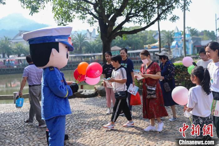 宣傳玩偶正在給游客贈送宣傳小禮品?！±钤x 攝