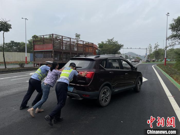 佛山高明公安警輔人員協(xié)助司機(jī)將故障車輛推至安全區(qū)域?！∥轲┤?攝