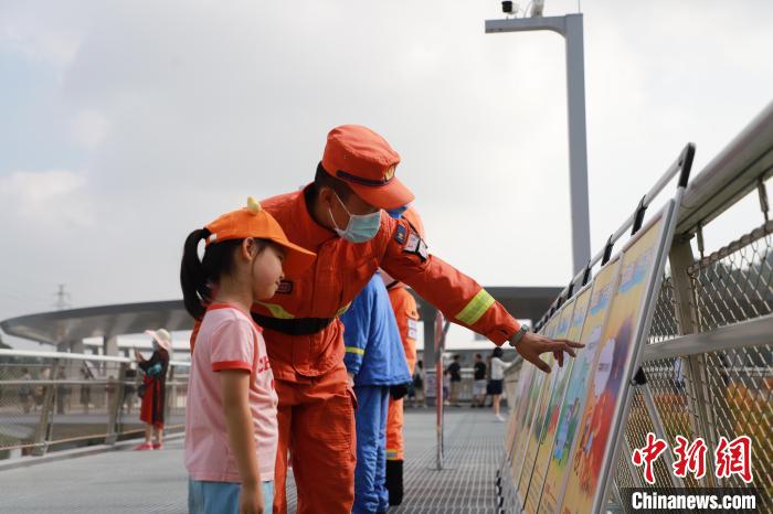 森林消防員正在防火宣傳展板前與小朋友進(jìn)行科普講解?！↑S山鴻 攝