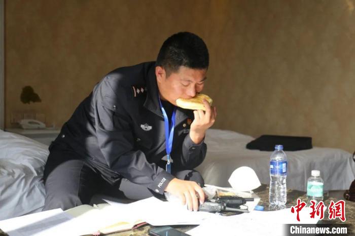 圖為李輝一邊吃飯一邊工作?！“蕉疾既?攝