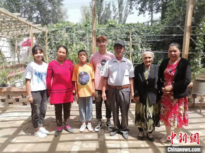 108歲老人努爾·依地熱斯(右二)喜愛勞作，澆花，喂羊，烤包子等都親力親為。圖為老人與部分子孫?！≈炀俺?攝