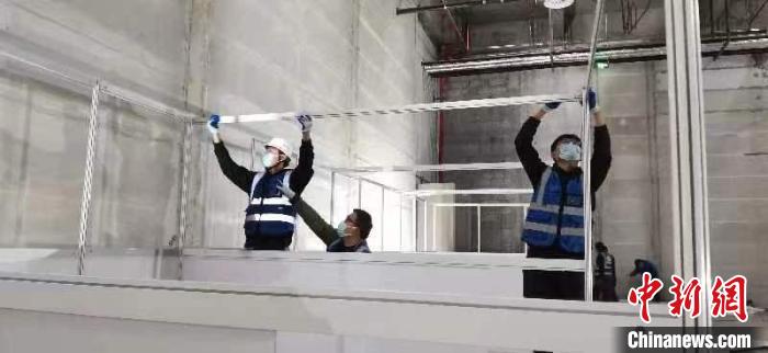 圖為工人搭建方艙醫(yī)院現(xiàn)場?！《毠﹫D