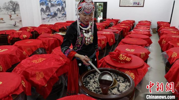 圖為藍(lán)春花在酒廠查看最新釀造的米酒?！∮浾呷A山 攝