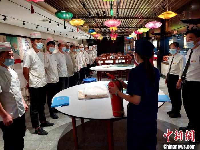 檢查期間，消防協(xié)管員為一家飯店后廚工作人員普及消防知識(shí)?！垘泿?攝