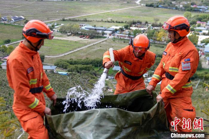 技能大練兵過程中，消防員在陡坡上向蓄水池注水?！±顕鵂c 攝