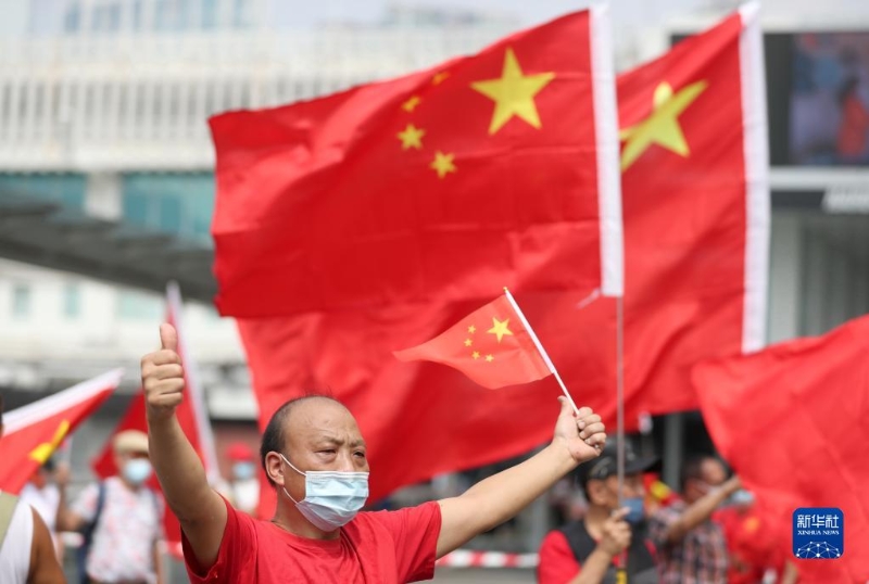 2021年10月1日，香港市民在尖沙咀揮舞國(guó)旗。（新華社記者 吳曉初 攝）