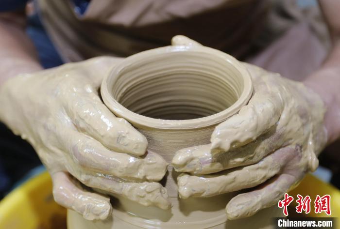 圖為張明正在進(jìn)行創(chuàng)意陶藝的定形工序?！￠T(mén)叢碩 攝