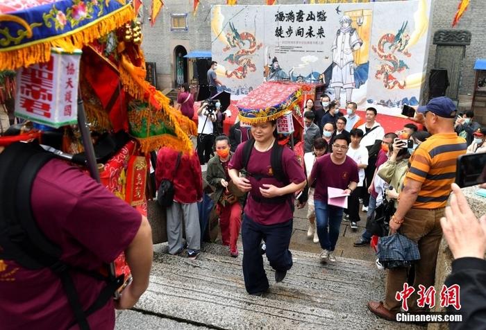 資料圖：5月12日，“福滿唐山路·徒步向未來(lái)”2022年兩岸青年信俗淵源尋根之旅活動(dòng)在福建福州啟幕，30多名閩臺(tái)青年恭請(qǐng)“福神”，背著端坐有關(guān)公、陳文龍神像的轎子從福州臺(tái)江區(qū)三通橋頭出發(fā)，開(kāi)啟一場(chǎng)祖脈尋根之旅。 <a target='_blank' href='/'>中新社</a>記者 呂明 攝