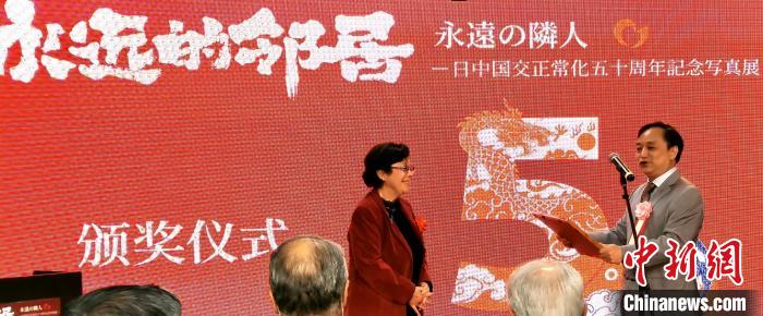 攝影展實(shí)行委員會(huì)中方代表劉莉生代表多元文化會(huì)館向日本前駐華大使阿南惟茂夫人阿南史代頒發(fā)獎(jiǎng)狀?！≈鬓k方供圖