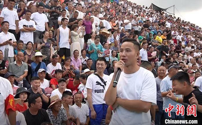 圖為臺盤村村民王再貴擔(dān)任球賽解說?！≡?攝