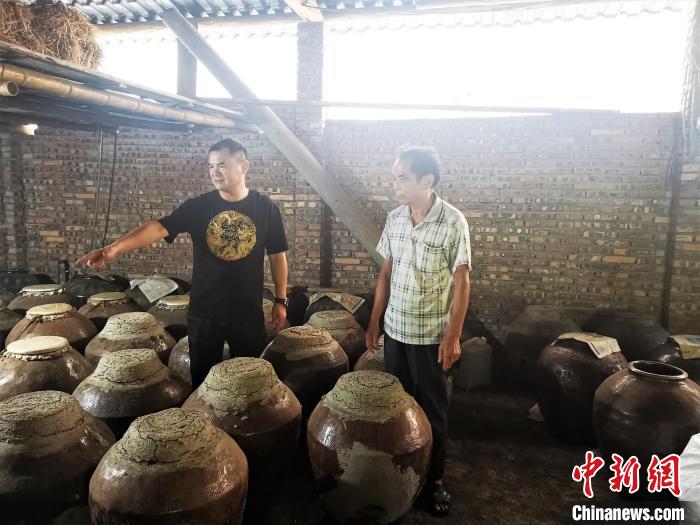 吳善遠(yuǎn)(左一)上門向農(nóng)戶收購黃酒?！∑聊峡h委組織部 供圖