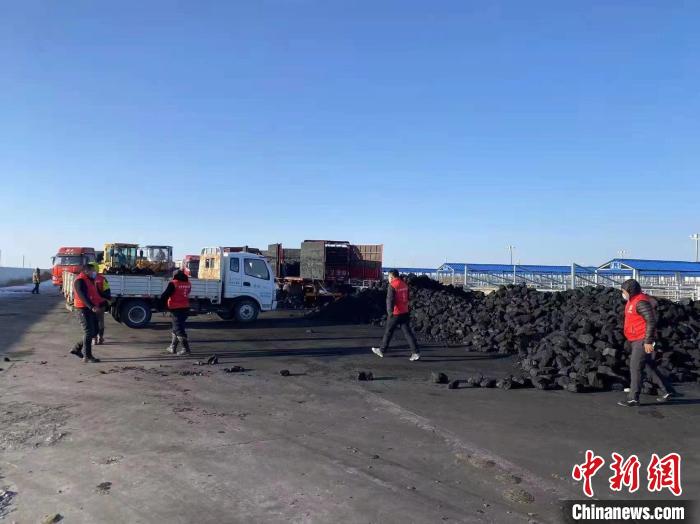 圖為工作人員正在協(xié)助牧民裝煤?！氁舳继m 攝