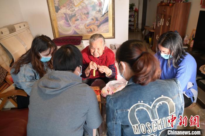 圖為周有玉在家中教授居民串珠手工藝品制作技藝。　陳鑫 攝