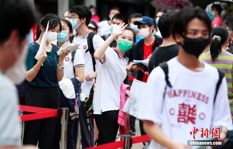 資料圖：一名考生在進(jìn)入考場(chǎng)前向家長(zhǎng)揮手致意。<a target='_blank' href='/'>中新社</a>記者 湯彥俊 攝