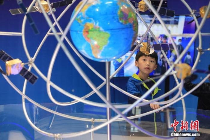資料圖：一位小朋友在參觀“北斗三號全球衛(wèi)星導航系統(tǒng)”模型。 瞿宏倫 攝