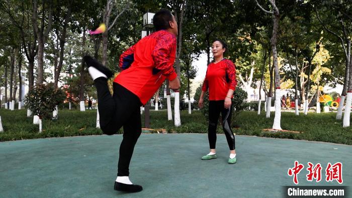 圖為白賀成(左一)和毽友在公園踢毽。　臧振清 攝