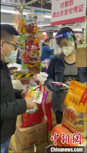 圖為范艷濤(左)在河南鄭州超市采購油條膨松劑?！∈茉L者供圖