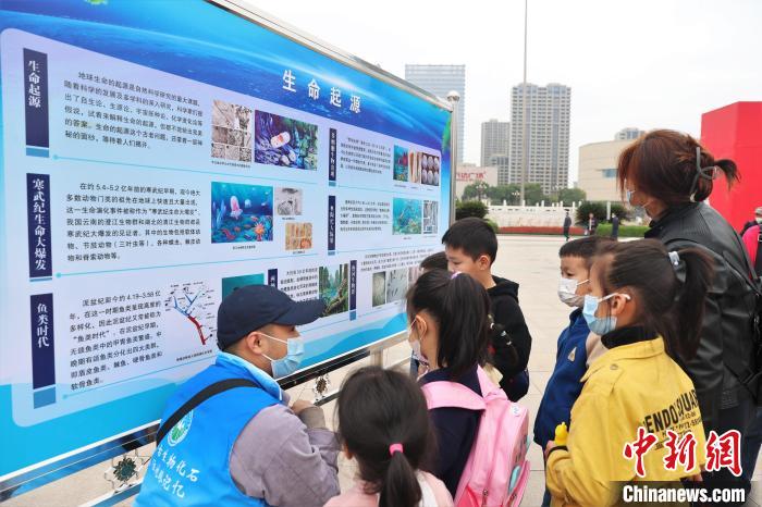 圖為2022年度江西省古生物化石保護利用科普宣傳活動南昌分會場，志愿者在給幾位小朋友講解科普知識?！⒘?攝