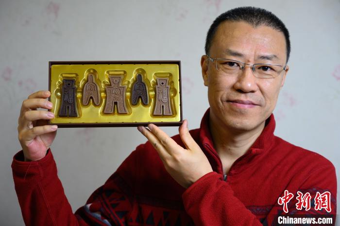 山西平面廣告設計師孫晟展示他設計制作的布幣巧克力。　韋亮 攝