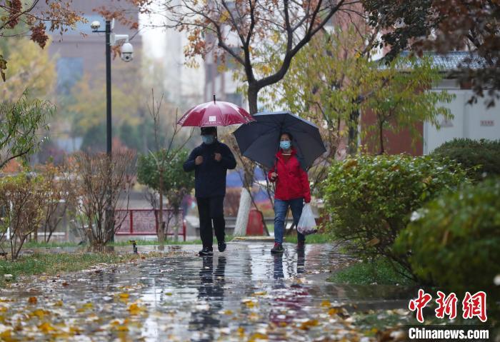 資料圖：市民雨中出行?！∮诰?攝