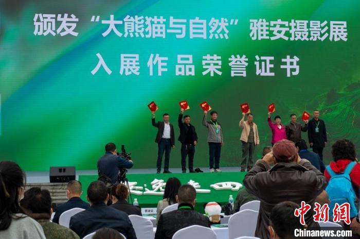 嘉賓為攝影展入選作者頒發(fā)證書?！⒅铱?攝