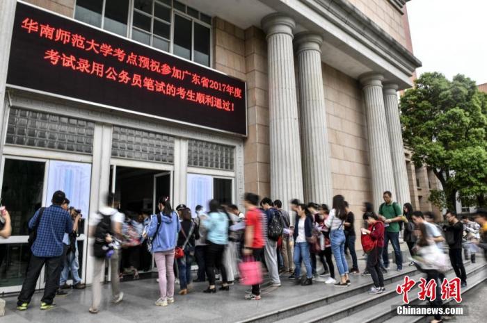 資料圖：華南師范大學(xué)考點(diǎn)，參加公務(wù)員考試的考生步入考場(chǎng)。<a target='_blank' href='/'>中新社</a>記者 陳驥旻 攝