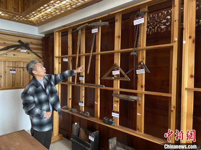 圖為葉偉平向前來參觀的民眾介紹修復(fù)古建筑時(shí)使用的工具?！⒂駶?攝