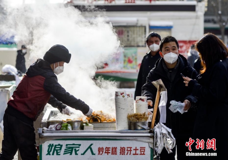 資料圖：外出購物的市民購買品嘗街頭小吃。 劉新 攝