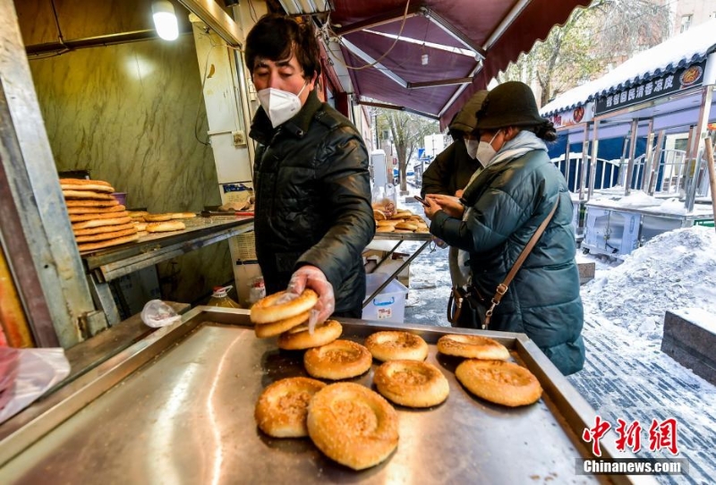 烏魯木齊市文化路，已開門營業(yè)的馕店吸引過往市民前來購買。 劉新 攝