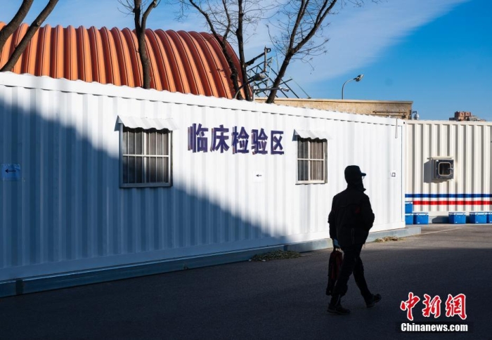 12月15日，北京市“健康豐臺”微信公眾號發(fā)布消息，為方便群眾就醫(yī)，豐臺區(qū)豐體方艙發(fā)熱門診今日開診。豐體方艙發(fā)熱門診位于豐臺區(qū)西四環(huán)南路55號豐臺體育中心院內(nèi)，全天24小時開診。主要服務(wù)16至65周歲，無基礎(chǔ)疾病，非急診、無有創(chuàng)治療的普通上呼吸道感染發(fā)熱患者。圖為一位市民經(jīng)過方艙發(fā)熱門診臨床檢驗區(qū)設(shè)施。 <a target='_blank' href='/'>中新社</a>記者 侯宇 攝