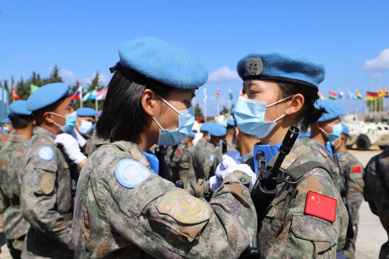 圖為2021年6月16日，在黎巴嫩南部辛尼亞村中國(guó)維和營(yíng)舉行的授勛儀式上，接受檢閱的維和女兵進(jìn)場(chǎng)前互相整理著裝。（新華社發(fā)）