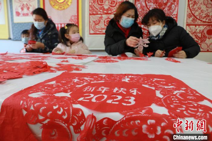 12月30日，在山東省高密市剪紙藝社，非遺傳承人和孩子們正在進行迎新年剪紙創(chuàng)作。　李海濤 攝
