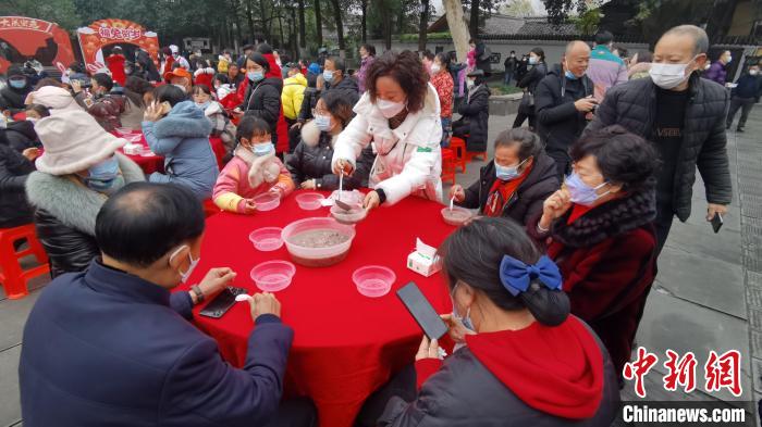 游客市民齊聚在一起，共品臘八粥。　王波 攝