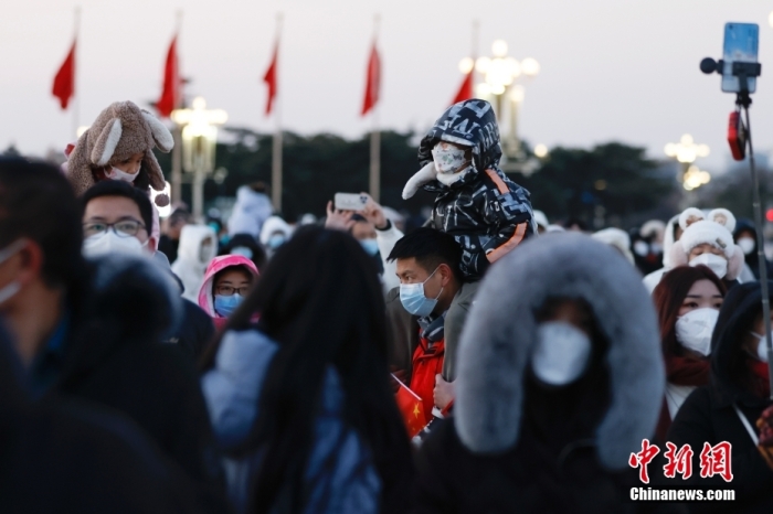 2023年1月1日晨，北京天安門廣場(chǎng)舉行隆重的升國(guó)旗儀式。人們來到天安門廣場(chǎng)觀看升旗儀式，迎接新年。 <a target='_blank' href='/'>中新社</a>記者 盛佳鵬 攝