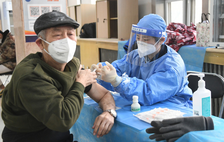 2022年12月15日，在北京市海淀區(qū)中關(guān)村街道新冠疫苗接種點(diǎn)，醫(yī)護(hù)人員為老年人接種新冠疫苗。（圖源：新華社）