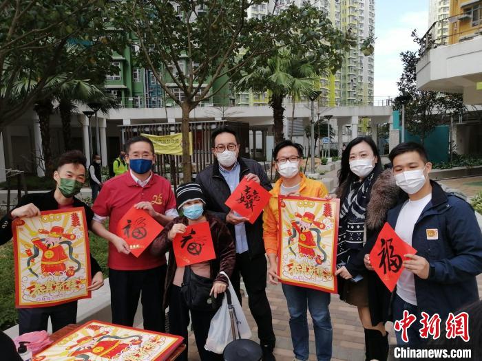 陳百里(左二)與義工一起向市民贈送揮春?！∠愀圯加﹫D