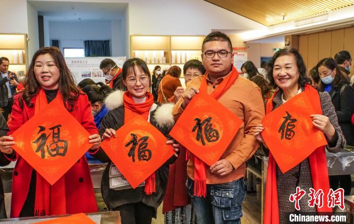 圖為臺(tái)胞在展示寫(xiě)好的“福”字?！∈Y豐慧 攝