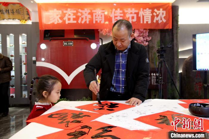 1月13日，山東濟(jì)南，書畫家現(xiàn)場(chǎng)潑墨，揮毫?xí)鴮懜Ｗ?、春?lián)?！O婷婷 攝
