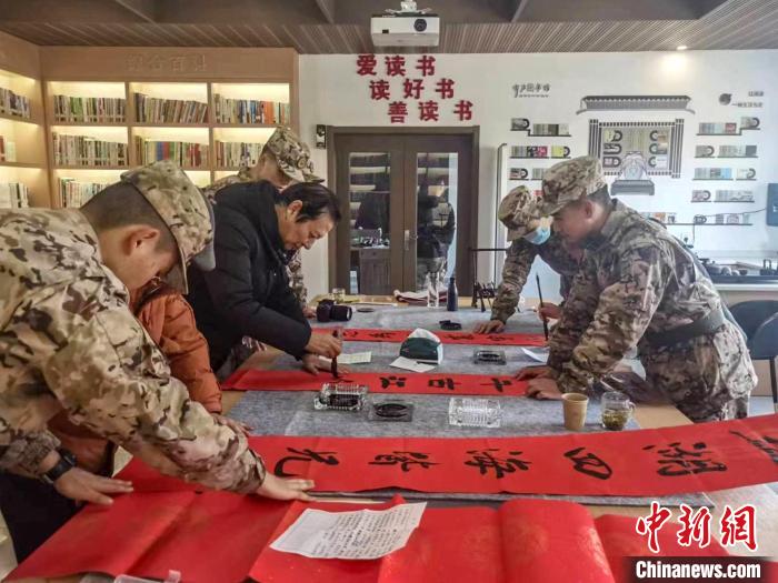 浙江衢州江山市離退休干部與武警衢州支隊江山中隊官兵共寫春聯(lián)。　卞宏寬 攝