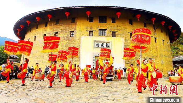 為豐富節(jié)日旅游內(nèi)容，永定土樓景區(qū)白天推出了大鼓涼傘舞等非遺項目表演?！∮蓝ㄍ翗蔷皡^(qū)供圖