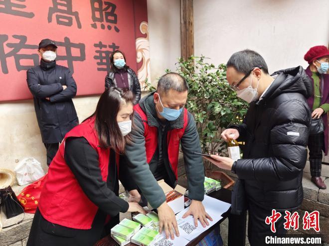 文藝志愿者向群眾發(fā)放“文明旅游安全出行”主題宣傳冊?！「＝ㄊ‰s技團供圖