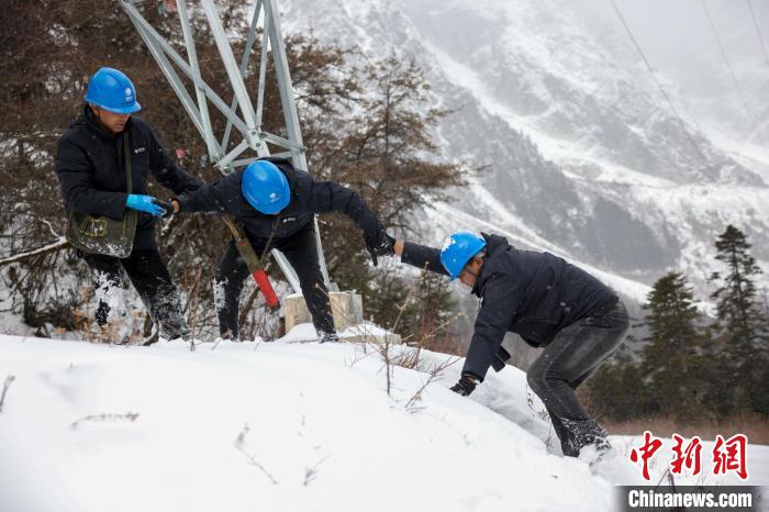 西藏波密縣電力巡護(hù)人員相互幫助，趟雪踏冰?！±顤|淮 攝