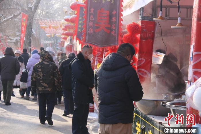 烏魯木齊市民在公園小吃攤上選購(gòu)食品?！∨绥?攝