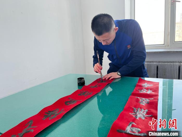 圖為森林消防指戰(zhàn)員自己動手寫春聯(lián)?！∶缱?攝
