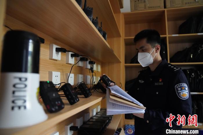 圖為民警黃昊正在清點整理執(zhí)法記錄儀?！⊥鯓s鑫 攝